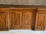a wooden cabinet with a marble top in a room