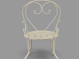 a white metal chair with a heart shaped back and arms