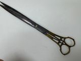 someone is holding a pair of scissors on a white surface