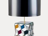 une photo d'une lampe de table sur laquelle est posé un cube en miroir