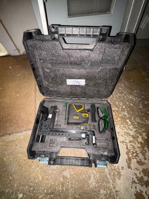 une mallette noire avec des outils à l'intérieur sur le sol
