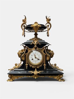 a black and gold clock sitting on top of a table