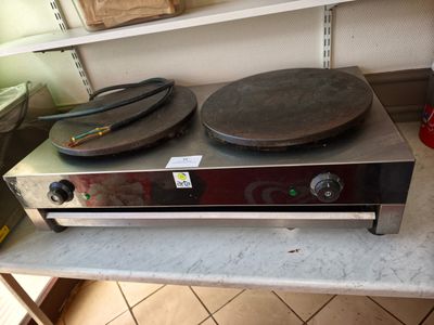une cuisinière avec une casserole posée dessus, dans une cuisine