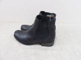 a close up of a pair of black ankle boots on a white surface