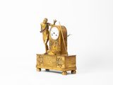 une horloge en or surmontée d'une statue