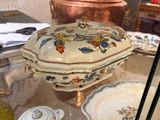 une vitrine en verre sur laquelle sont posés un saladier et des assiettes