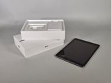 une tablette posée dans une boîte à côté d'un téléphone portable