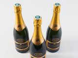 three bottles of champagne are sitting on a white surface