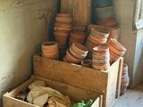 une pile de casseroles dans une caisse en bois, dans un coin de la pièce