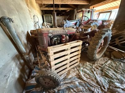 de nombreux vieux tracteurs dans une pièce où il y a beaucoup de bois