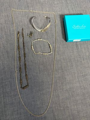un gros plan sur un collier, un bracelet et une bague posés sur une table