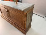 a wooden chest with a marble top on a white floor