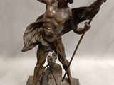 bronze statue of a man with a spear and shield on a base