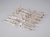 six objets plaqués argent sur une surface blanche