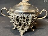 a silver bowl with a lid on a table