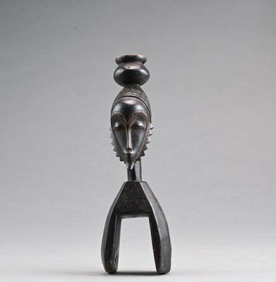 une sculpture noire représentant une femme dont la tête repose sur une fourchette
