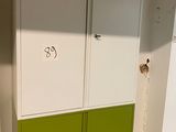 a green and white cabinet in the corner of a room