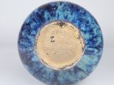 a blue and yellow vase sitting on a white surface