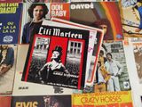 a lot of records on a table with a rainbow in the background