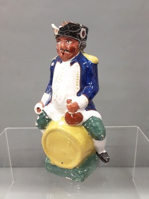 a figurine of a man sitting on top of a barrel