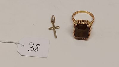 deux bagues et une croix posées sur une table blanche