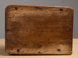 an old wooden box sitting on top of a table next to a gray wall