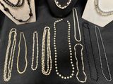 several necklaces and bracelets are displayed on a table