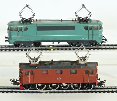 two trains that are sitting on the tracks together