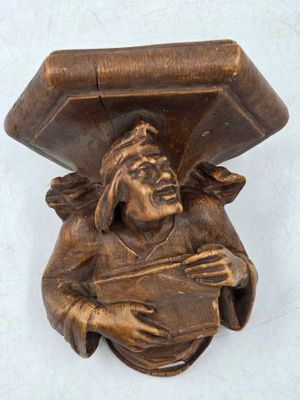 une statue représentant un homme tenant une boîte sur la tête