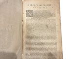 an old book opened to reveal a page of text on a white background