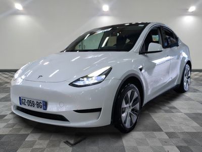 the white tesla model y is parked in a showroom
