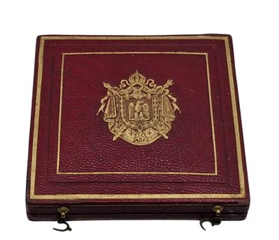 un vieux livre rouge avec un emblème doré sur la couverture