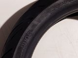 a close up of a tire on a white surface next to a wall