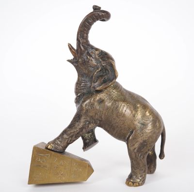 statue of an elephant balancing on a block on a white background