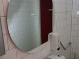a bathroom with a sink, mirror, and toilet paper dispenser