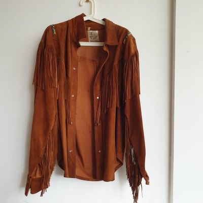 veste marron à franges suspendue à un cintre