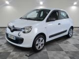 la petite voiture blanche est garée sur un sol en damier