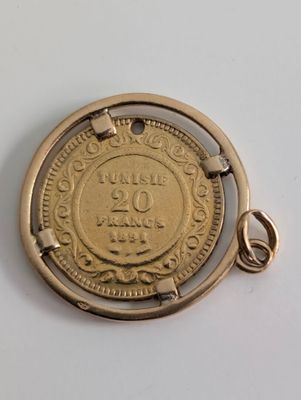 Une image représentant une pièce d'or est représentée sur une surface blanche