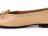the woman ' s shoes are tan and black with a bow on the toe