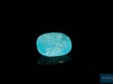 a blue stone on a black surface with a black background
