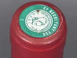 a close up of a red wine bottle with a green label