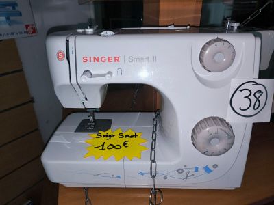 a white sewing machine sitting on a table with a price tag on it
