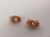 two gold rings sitting on top of a table next to each other