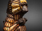 a close up of a wooden statue of a man holding a bird