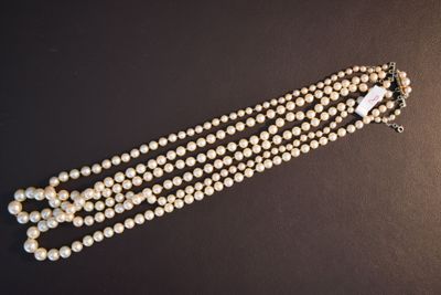 gros plan d'un collier de perles sur une surface noire