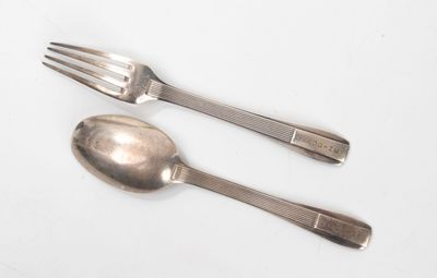 deux cuillères et une fourchette sur une surface blanche