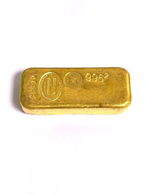 un lingot d'or posé sur une surface blanche, sur fond blanc