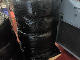a stack of black plastic bags sitting on a pallet next to a machine