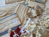 de nombreux morceaux de dentelle disposés sur un couvre-lit étendu sur le lit