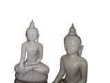 deux statues de bouddhas assis sur une surface blanche
